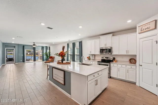 a kitchen with stainless steel appliances granite countertop a sink a stove and cabinets