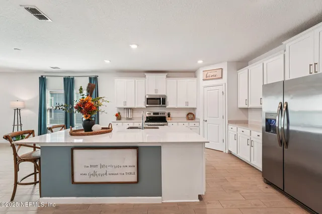 a kitchen with stainless steel appliances a sink dishwasher a stove top oven a counter space and cabinets