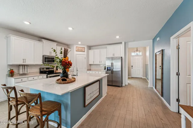 a view of a kitchen counter top space with furniture and wooden floor