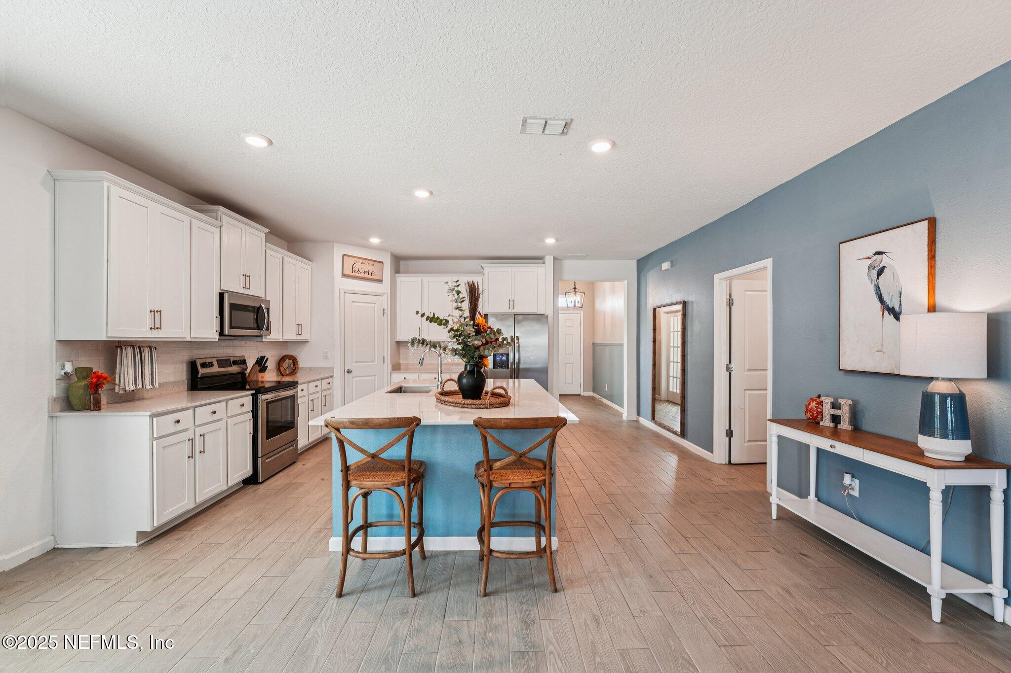 428 Lake Sinclair Street St. Augustine, FL 32084 - Photo 17 of 72 a kitchen with white cabinets and stainless steel appliances