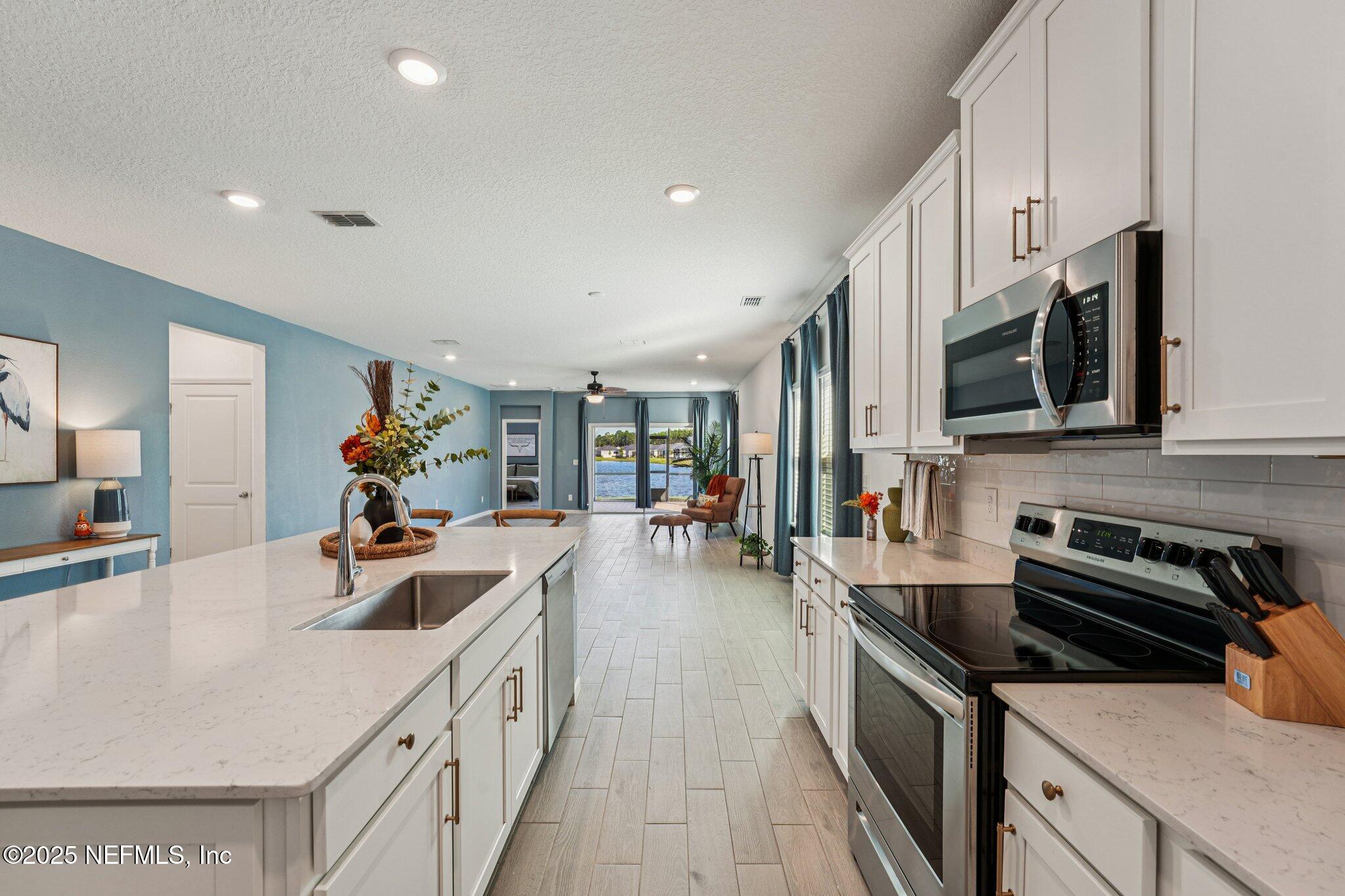 428 Lake Sinclair Street St. Augustine, FL 32084 - Photo 20 of 72 a kitchen with stainless steel appliances a sink dishwasher a stove top oven a counter space and cabinets