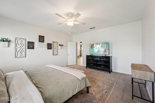 a bedroom with a large bed and a chandelier