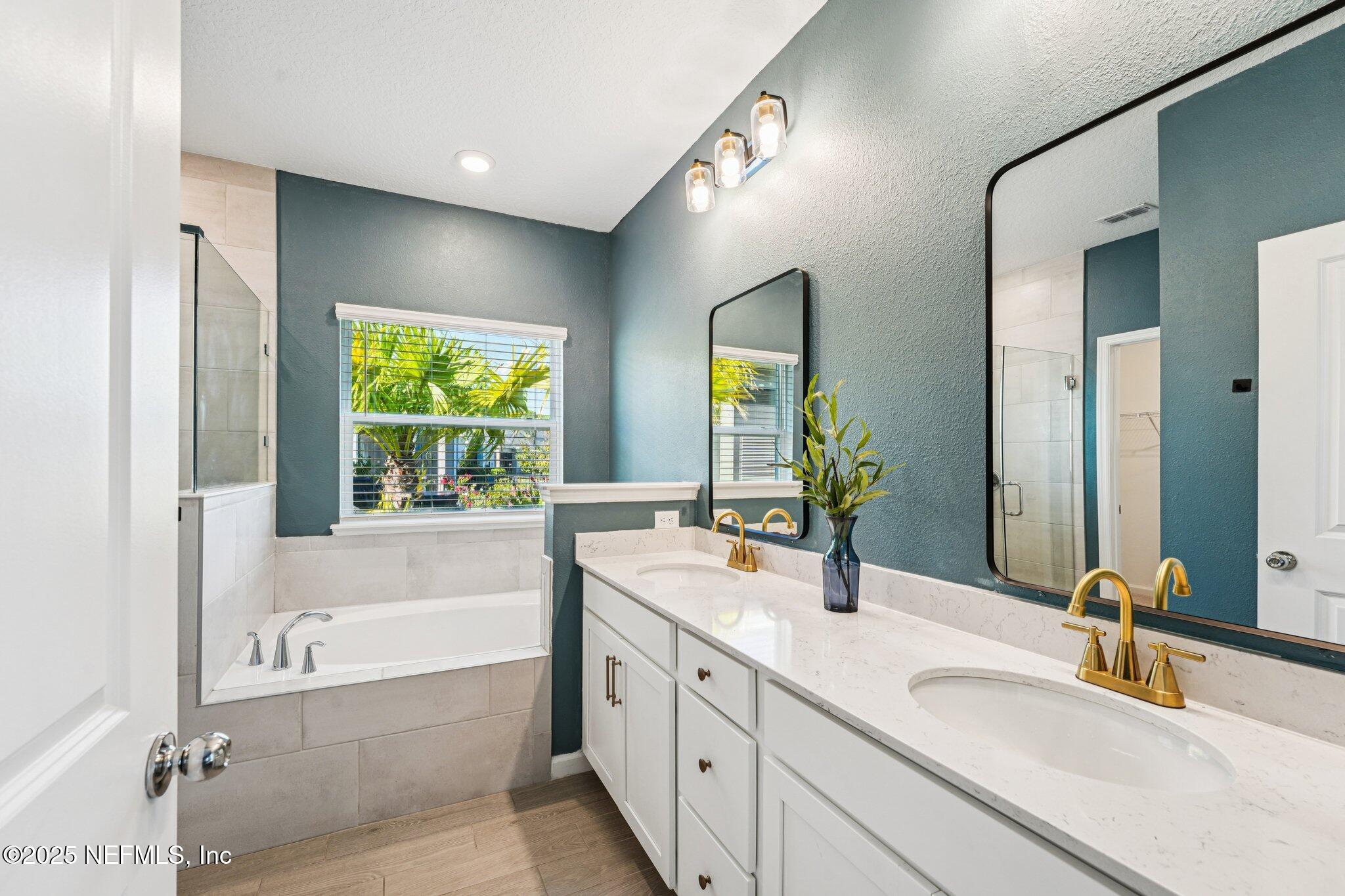 428 Lake Sinclair Street St. Augustine, FL 32084 - Photo 28 of 72 a bathroom with a tub sink and mirror