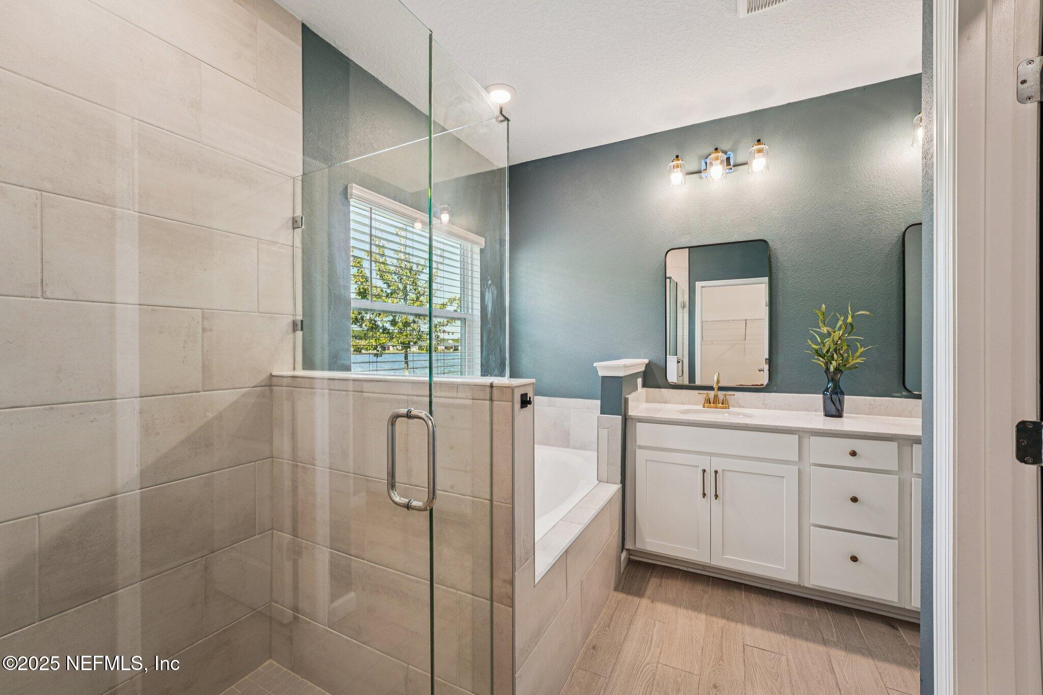 428 Lake Sinclair Street St. Augustine, FL 32084 - Photo 31 of 72 a bathroom with a double vanity sink a large mirror and a bathtub