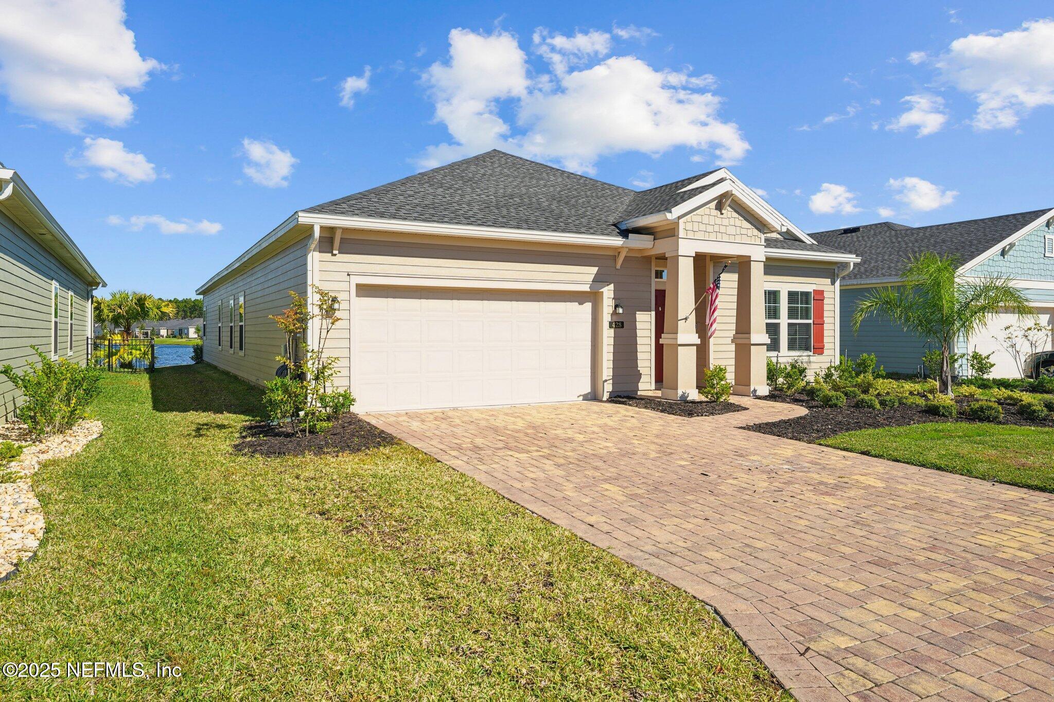 428 Lake Sinclair Street St. Augustine, FL 32084 - Photo 4 of 72 a front view of a house with a yard and garage