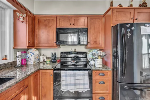 a kitchen with stainless steel appliances granite countertop a refrigerator and a stove top oven