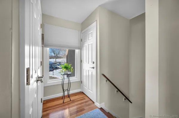 a view of a hallway with wooden floor and a livingroom