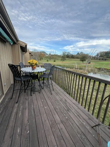 a balcony with wooden floor table and chairs