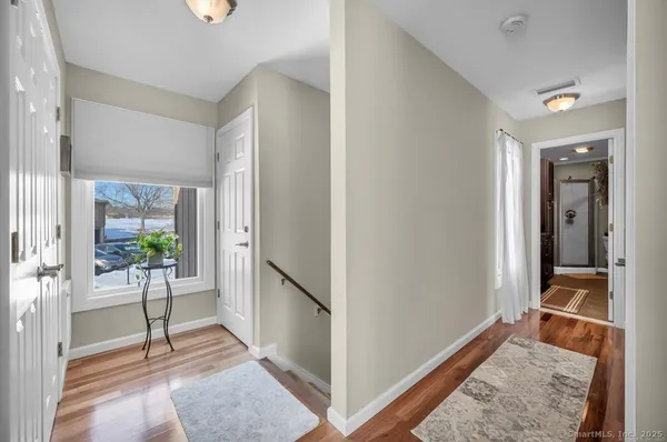 a view of a hallway with wooden floor and a living room