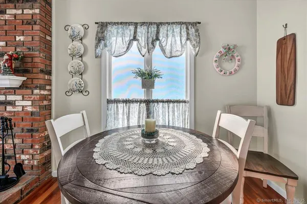 a view of a dining room with furniture a rug and wooden floor