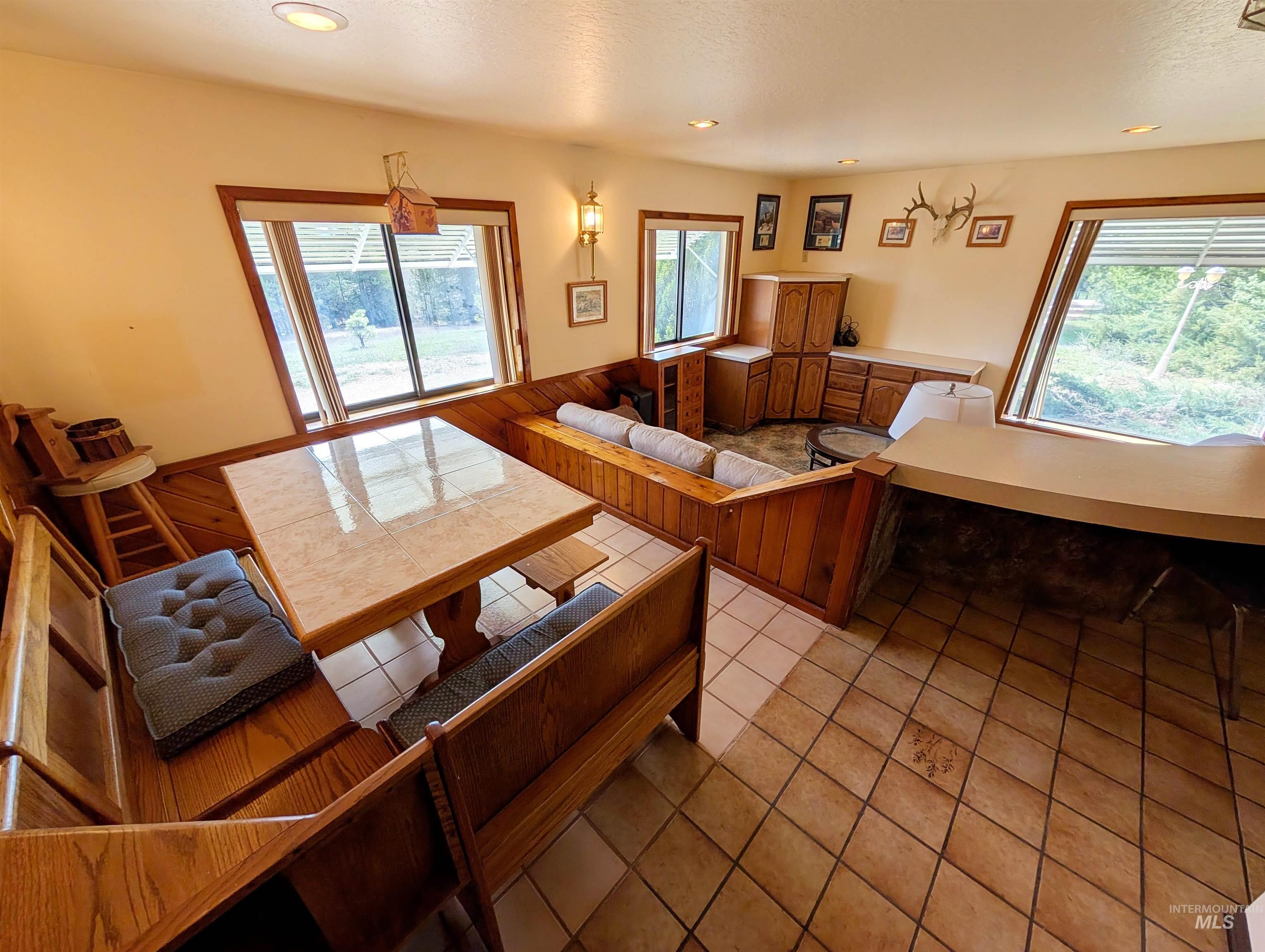 11100 Bens Road Cascade, ID 83611 - Photo 18 of 35 Tiled flooring throughout this space featuring built-in wood cabinetry, a breakfast bar, and multiple windows