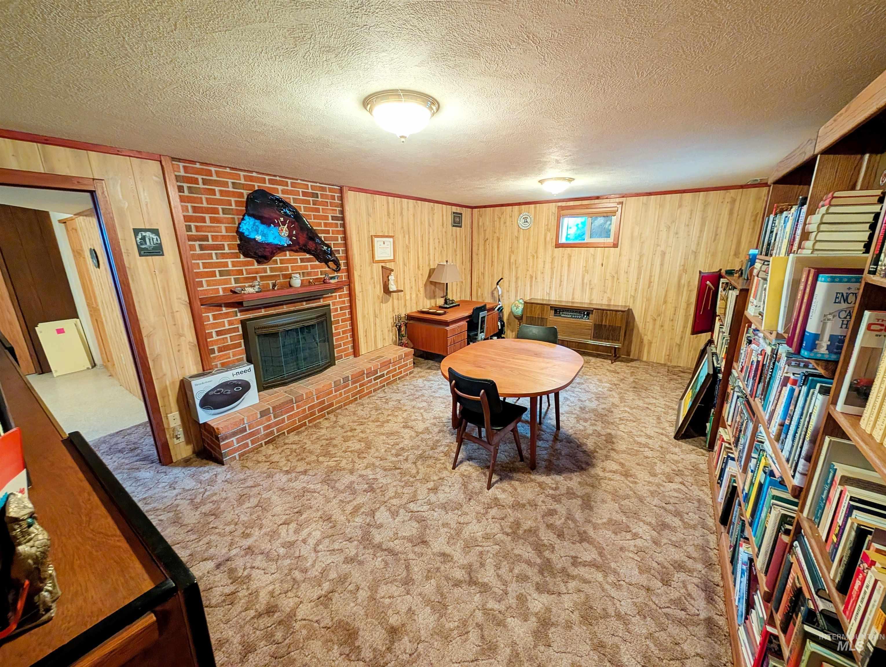 11100 Bens Road Cascade, ID 83611 - Photo 22 of 35 Spacious room featuring wood-panel walls and a brick fireplace