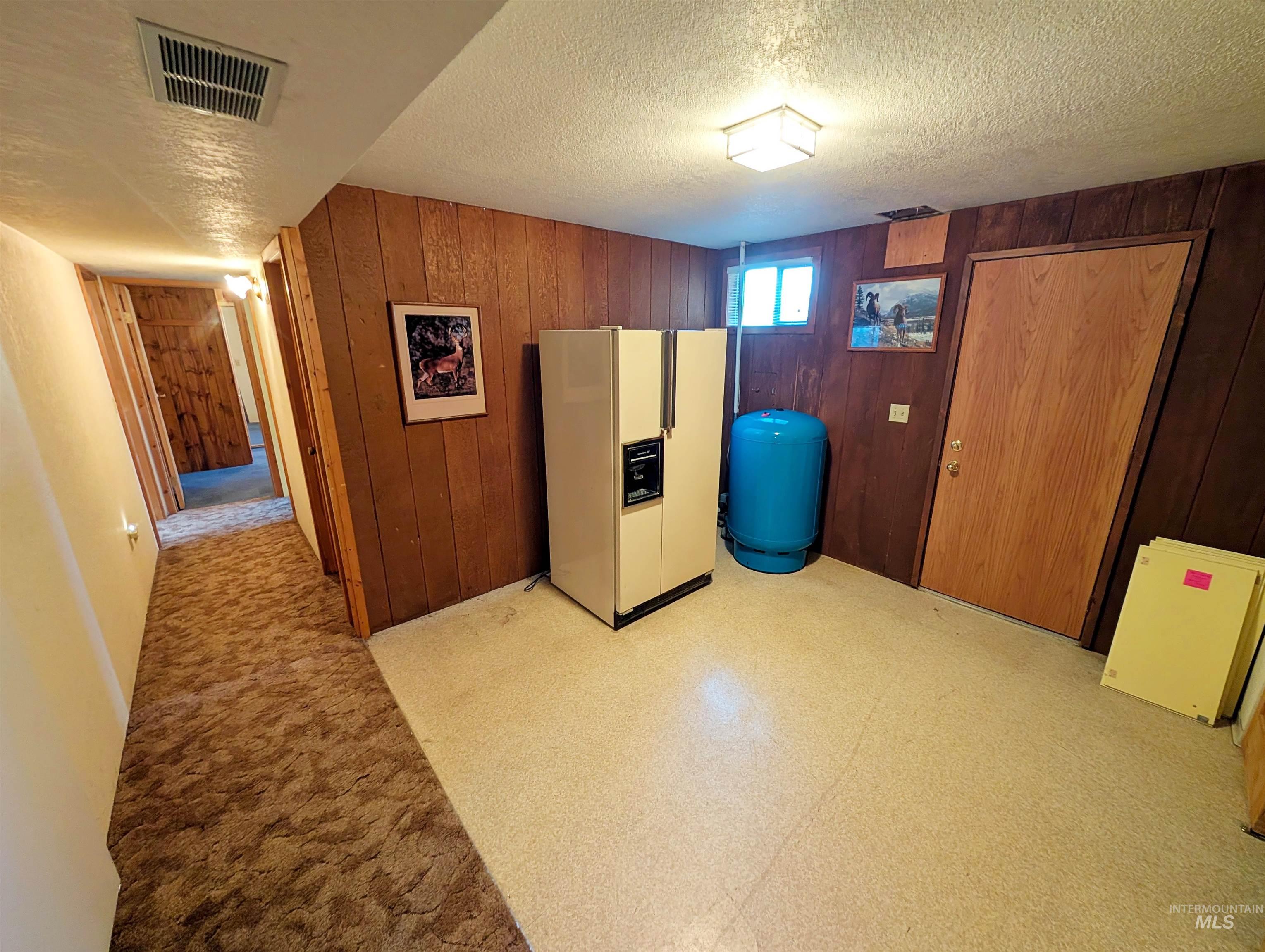 11100 Bens Road Cascade, ID 83611 - Photo 23 of 35 Recreational room featuring wood paneling, a flush-mount ceiling light fixture, and a window