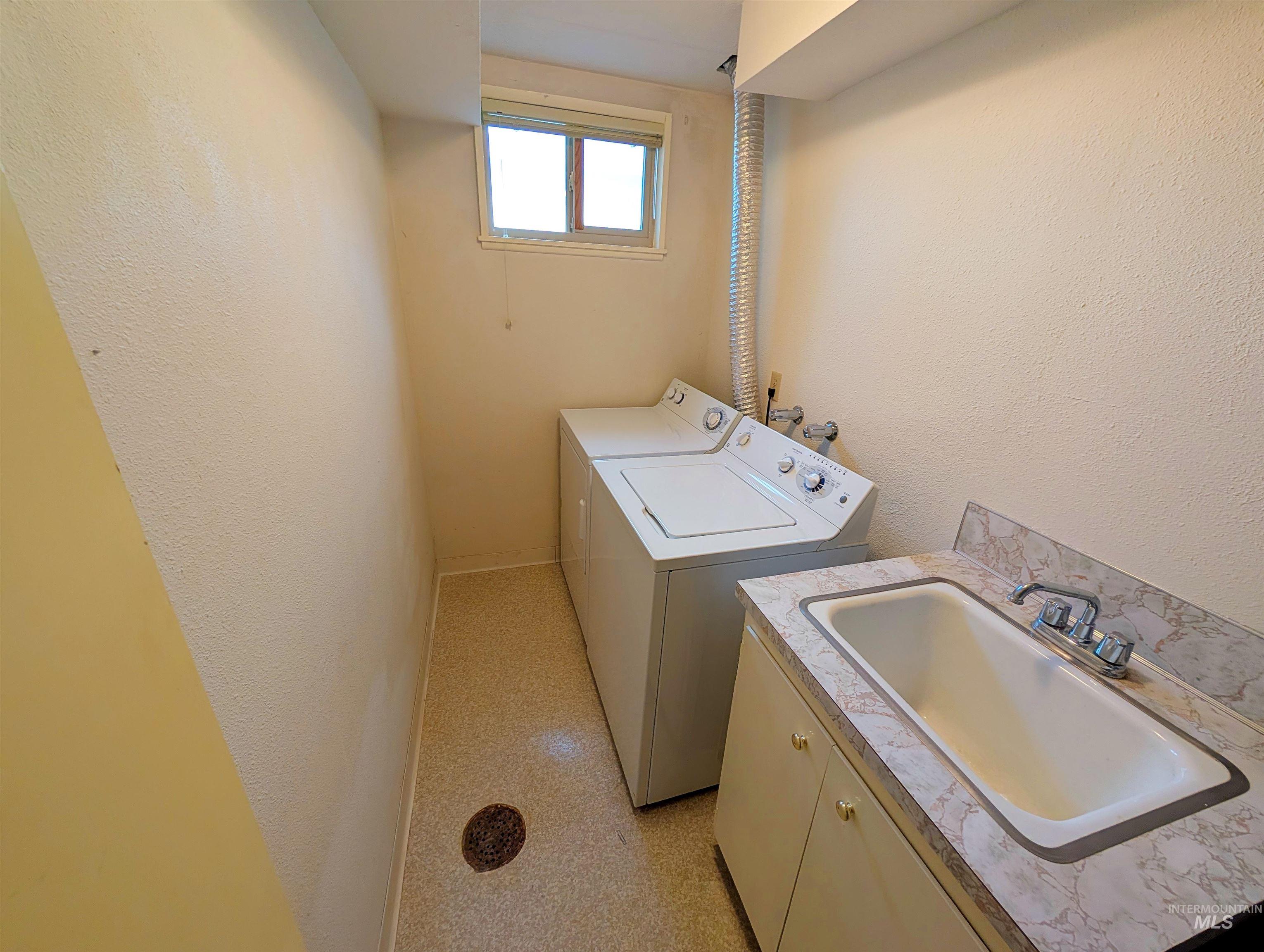 11100 Bens Road Cascade, ID 83611 - Photo 32 of 35 Laundry area featuring a utility sink with a laminate countertop, base cabinetry, and a window