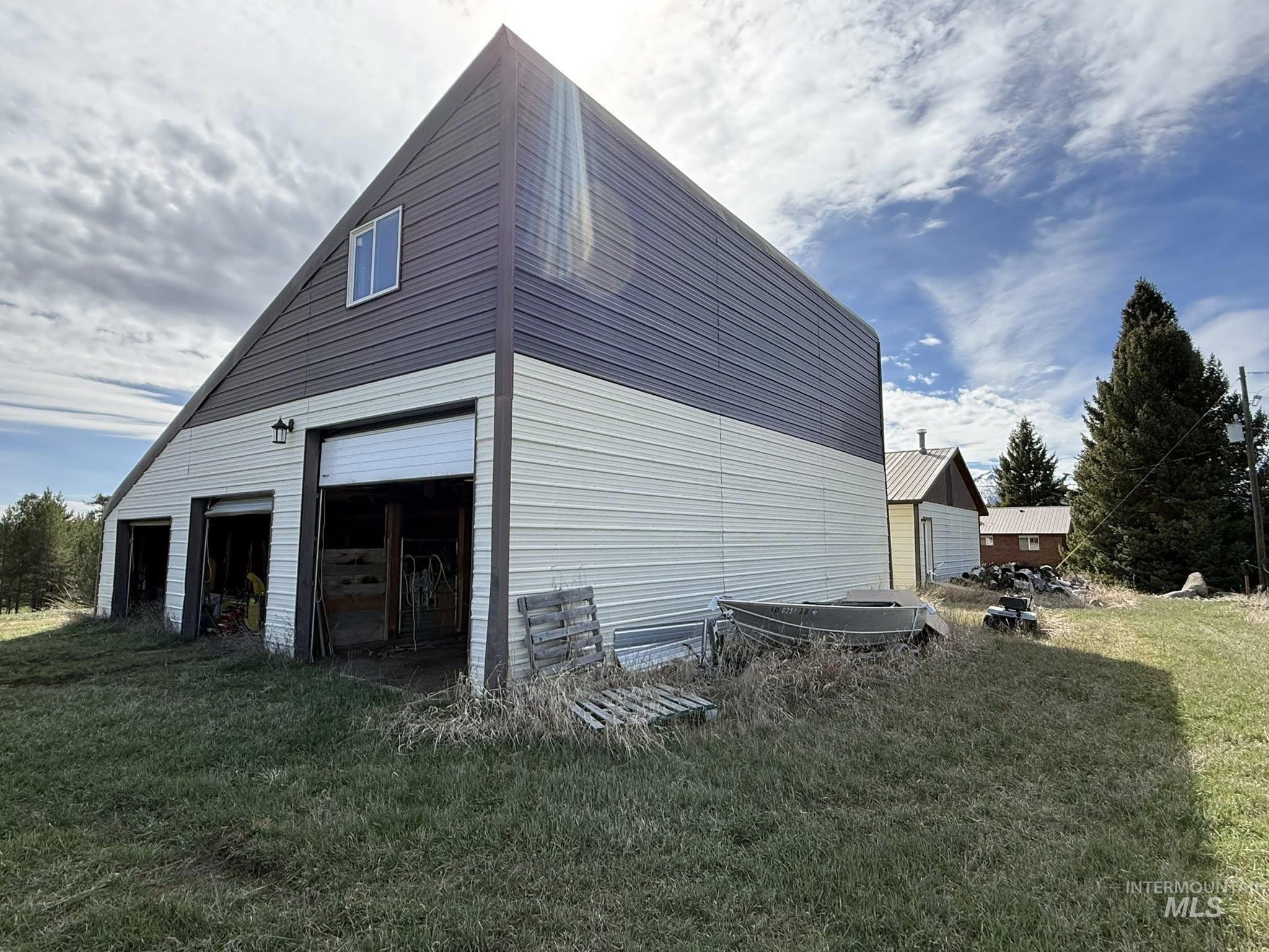 11100 Bens Road Cascade, ID 83611 - Photo 4 of 35 Two-story barn structure with two roll-up doors and a third open bay
