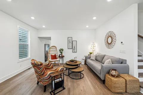 a living room with furniture and a wooden floor
