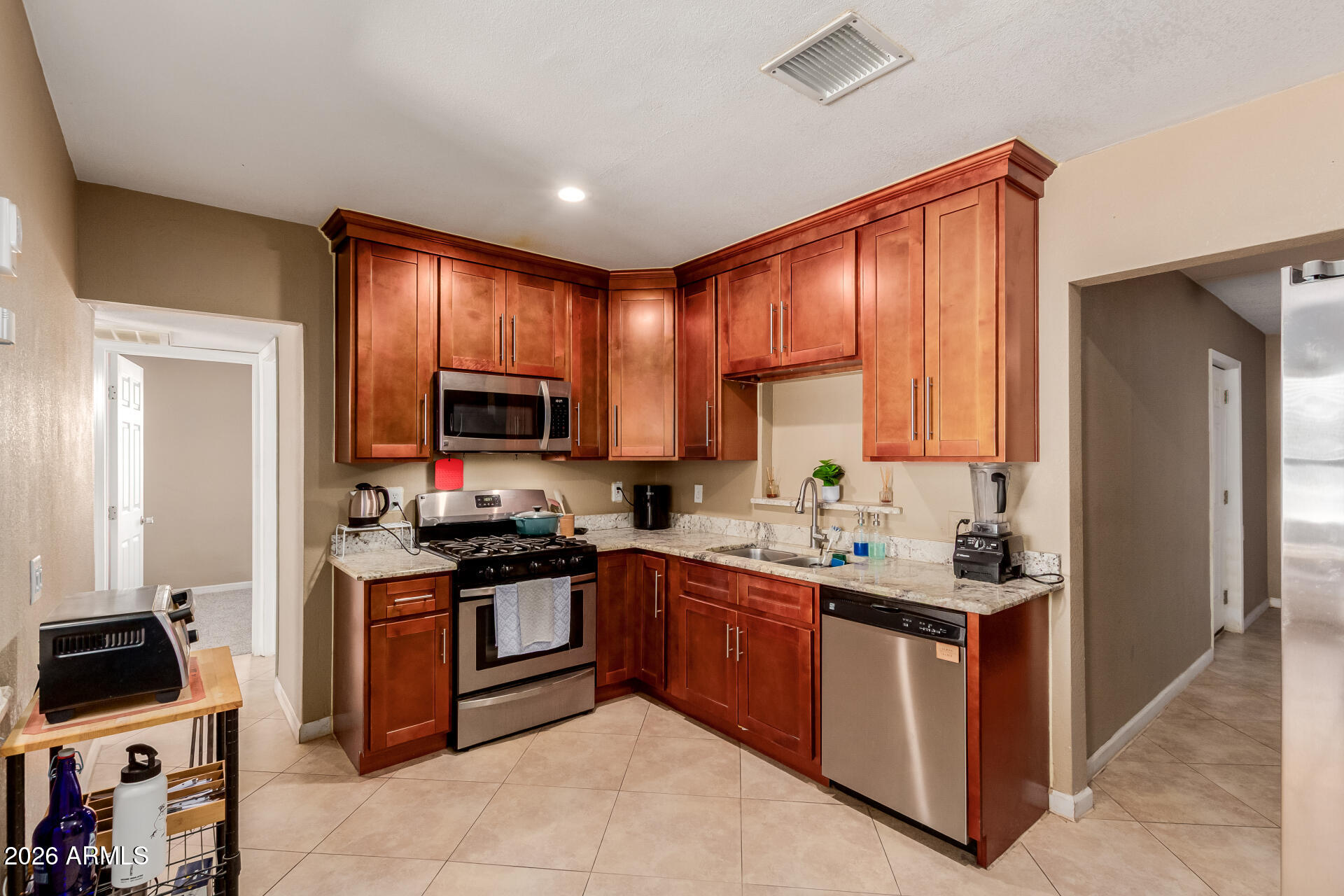 1644 West Sonora Street Phoenix, AZ 85007 - Photo 9 of 29 a kitchen with stainless steel appliances granite countertop wooden cabinets a sink and a stove