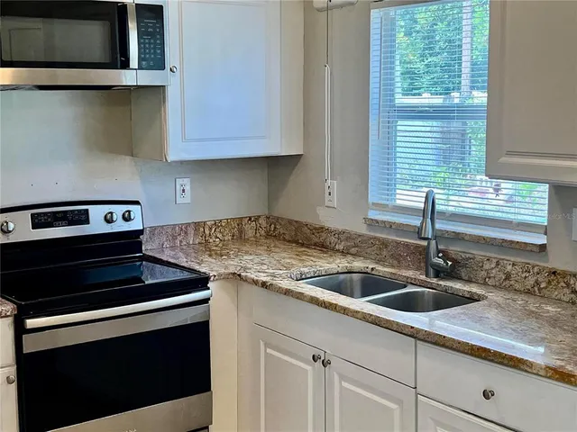 a kitchen with granite countertop a sink and a stove