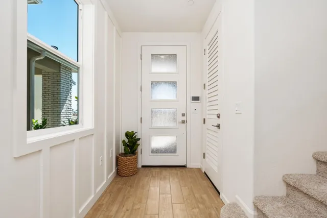 a hall way with wooden floor and a bathroom