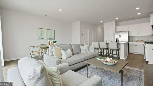 a living room with furniture and kitchen view
