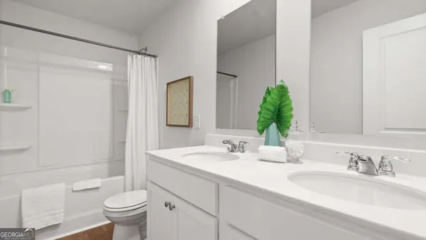 a bathroom with a double vanity sink toilet and shower