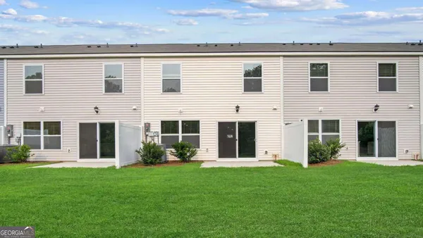a view of a house with backyard garden and plants