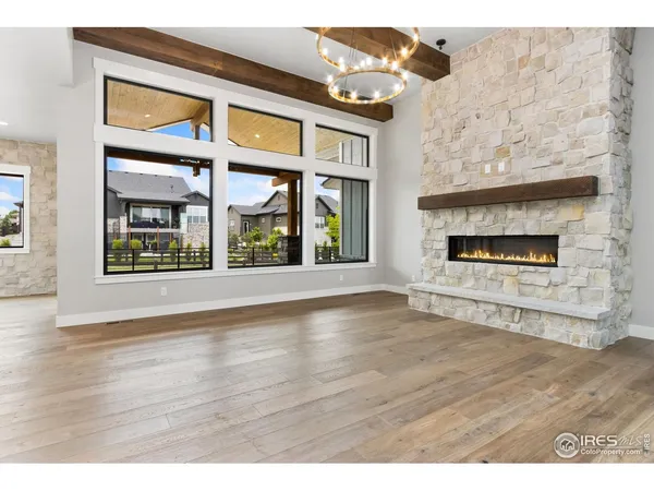 an empty room with wooden floor fireplace and windows
