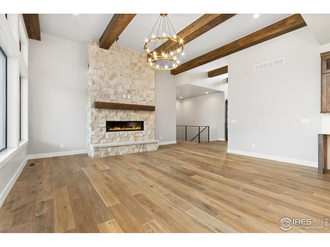 6325 Sanctuary Drive Windsor, CO 80550 - Photo 14 of 42 a view of an empty room with wooden floor fireplace and a window