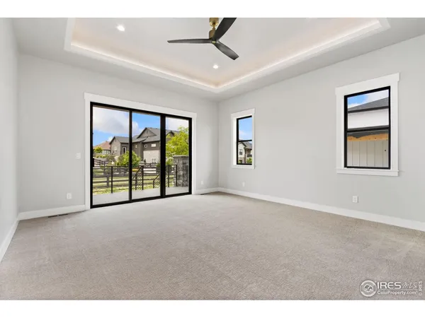 a view of an empty room with a window and a ceiling fan