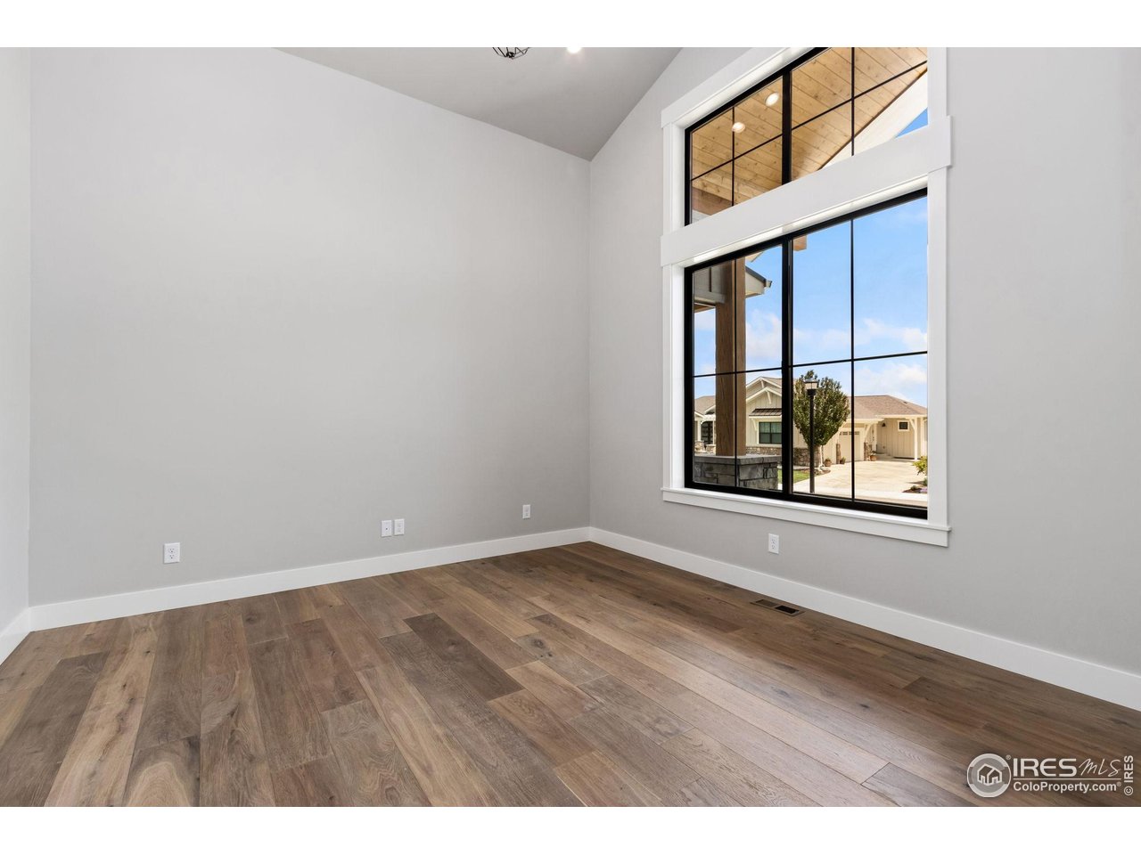6325 Sanctuary Drive Windsor, CO 80550 - Photo 23 of 42 an empty room with wooden floor and windows
