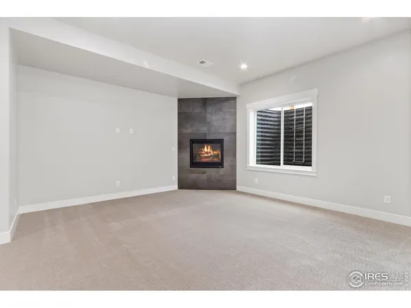 an empty room with a fireplace and windows