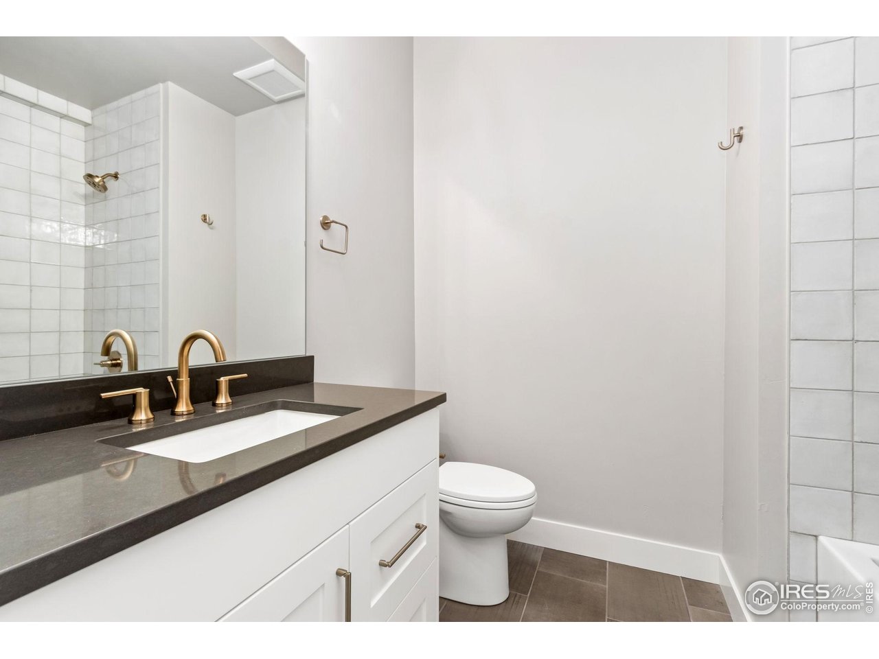 6325 Sanctuary Drive Windsor, CO 80550 - Photo 32 of 42 a bathroom with a granite countertop sink a toilet and a mirror