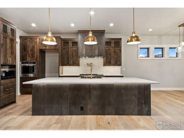 a kitchen with kitchen island a counter top space a sink stainless steel appliances and cabinets