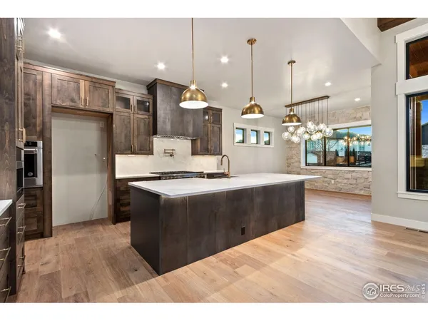 a kitchen with kitchen island a counter top space a sink appliances and cabinets