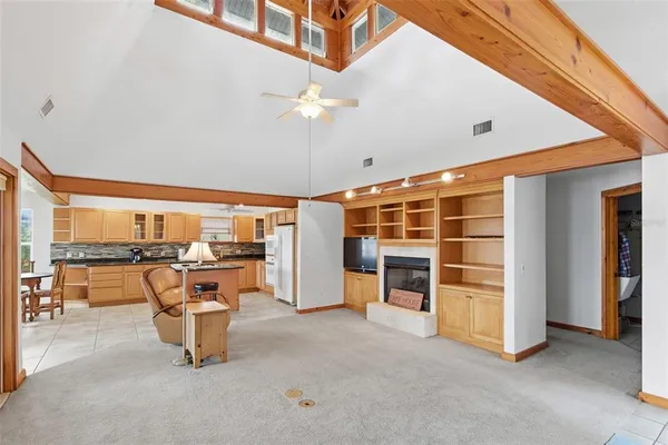 a living room with furniture a flat screen tv and a floor to ceiling window