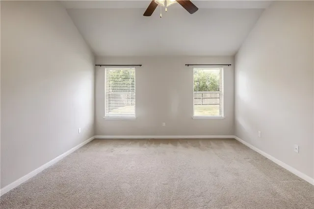 an empty room with closet and a ceiling fan