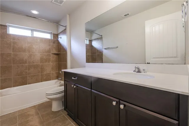 an empty room with a ceiling fan and a view of bathroom