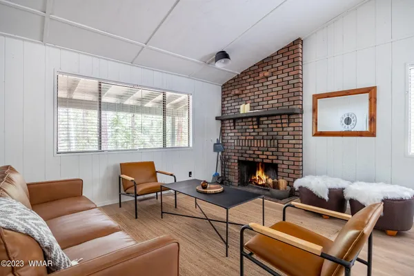 a living room with furniture a fireplace and next to a window