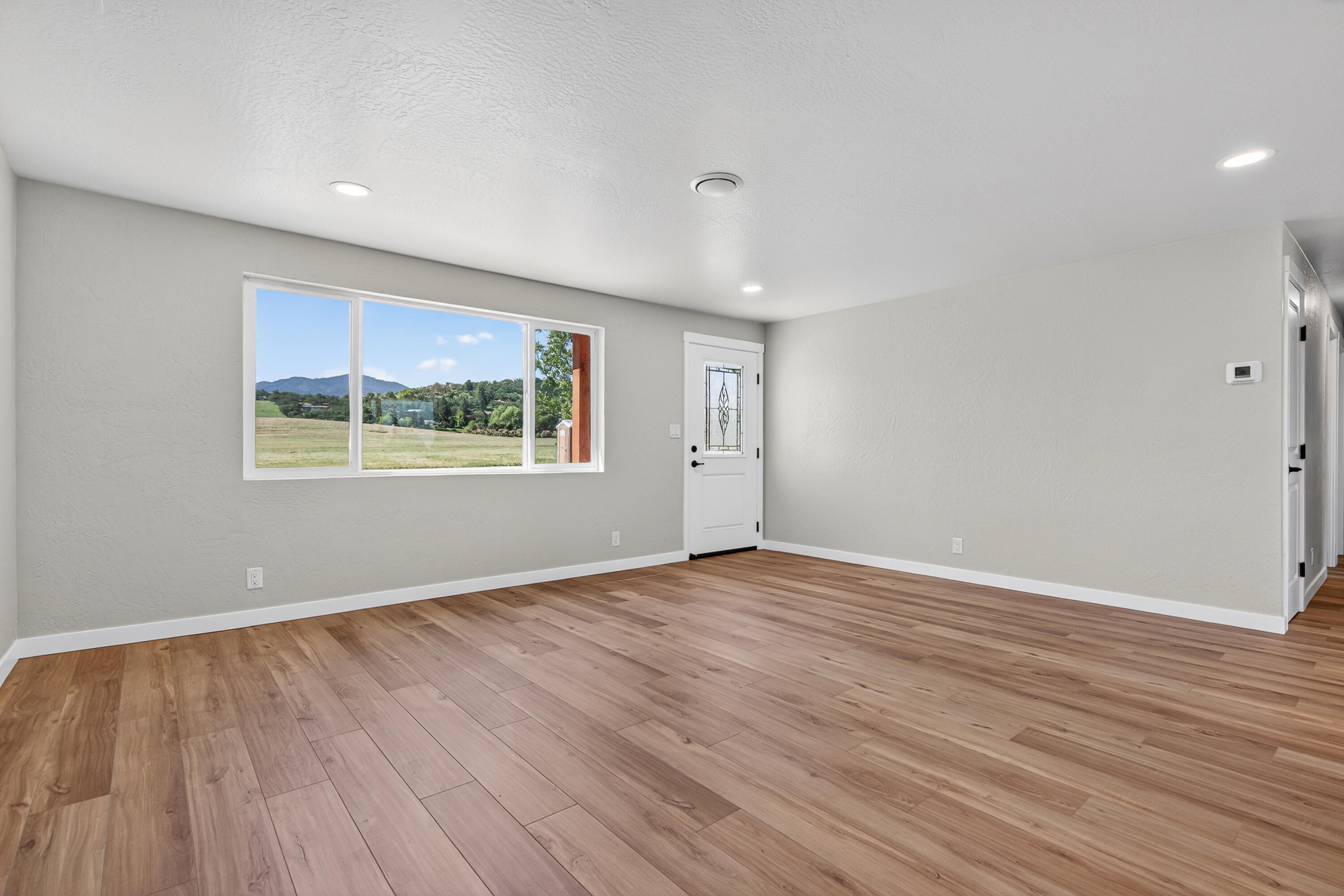 550 Experiment Station Road Medford, OR 97501 - Photo 4 of 27 a view of an empty room with wooden floor and a window