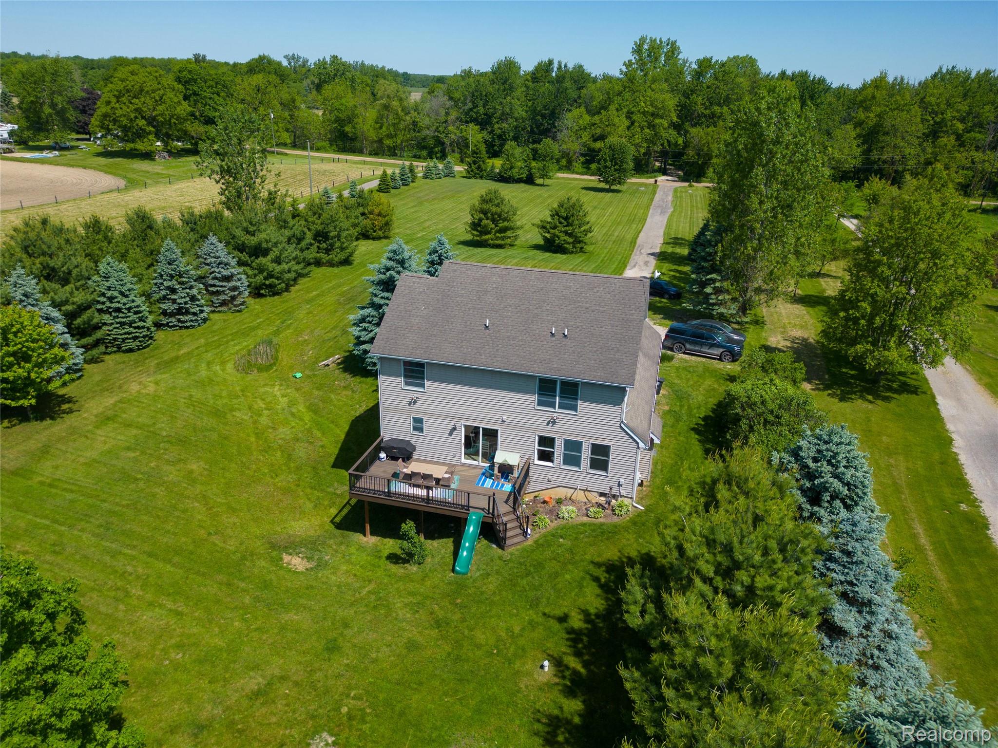 9191 Judd Road Fowlerville, MI 48836 - Photo 71 of 74 Two-story residence with a shingled roof and light gray siding