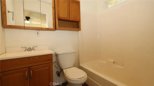 a bathroom with a granite countertop toilet a sink and a bathtub