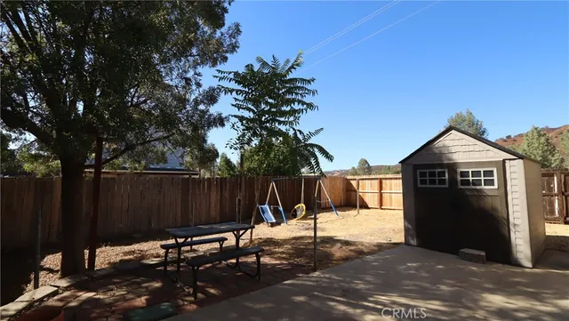 a view of a chairs and fire pit in the backyard of a house