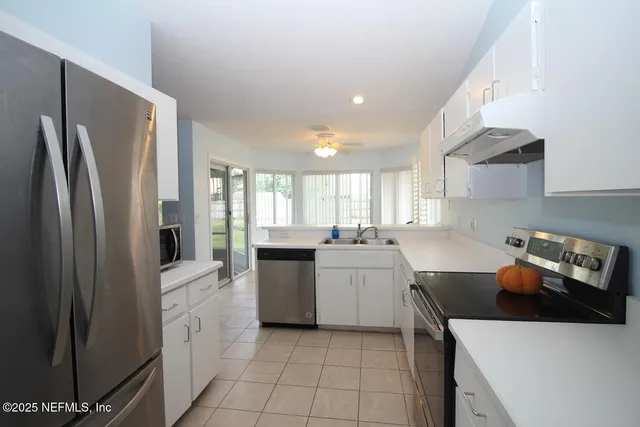 a kitchen with a sink a refrigerator and cabinets
