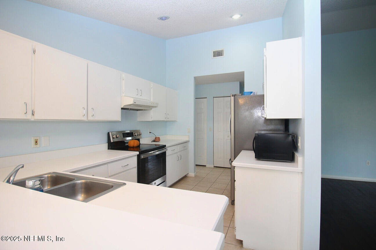 48 Westover Lane Palm Coast, FL 32164 - Photo 9 of 20 a kitchen with a sink a stove and refrigerator