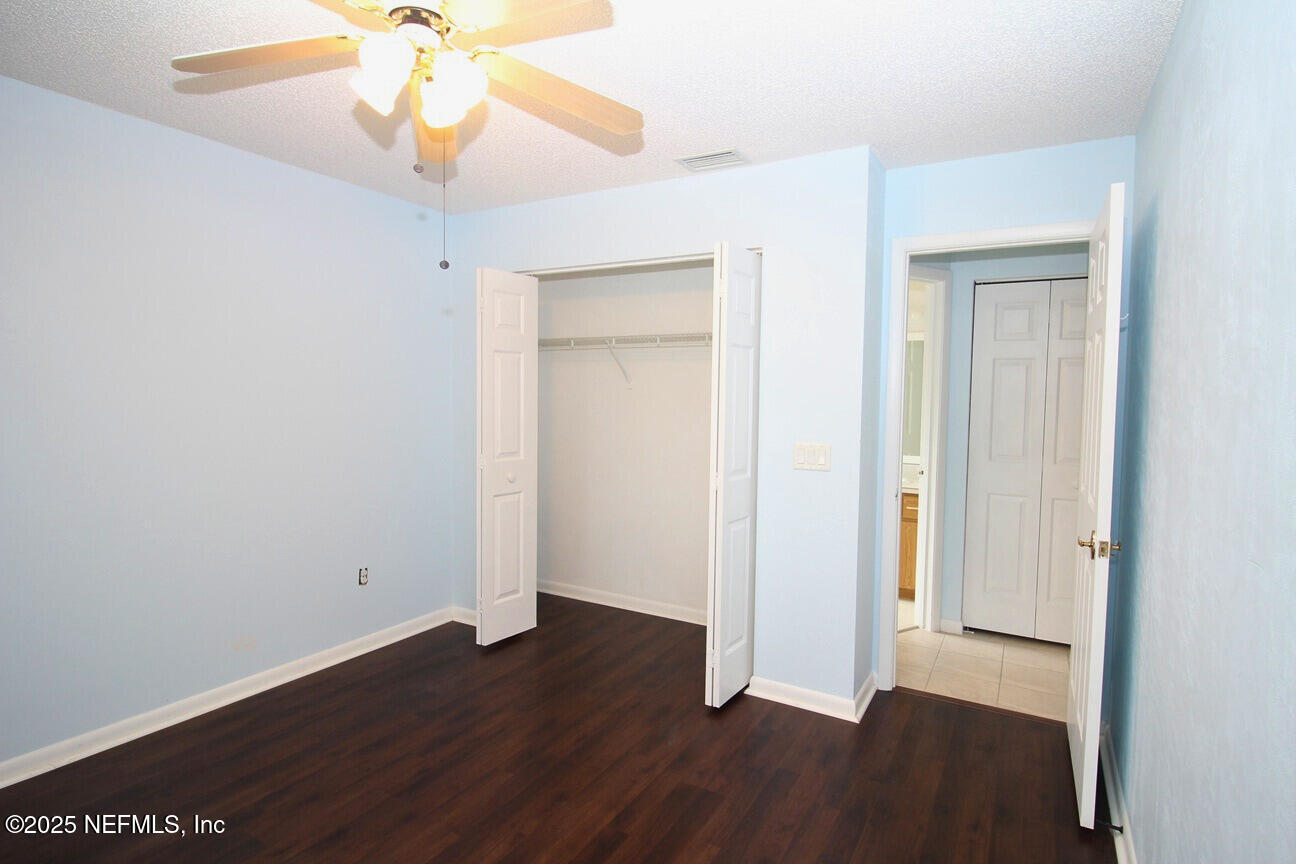 48 Westover Lane Palm Coast, FL 32164 - Photo 10 of 20 an empty room with wooden floor and door