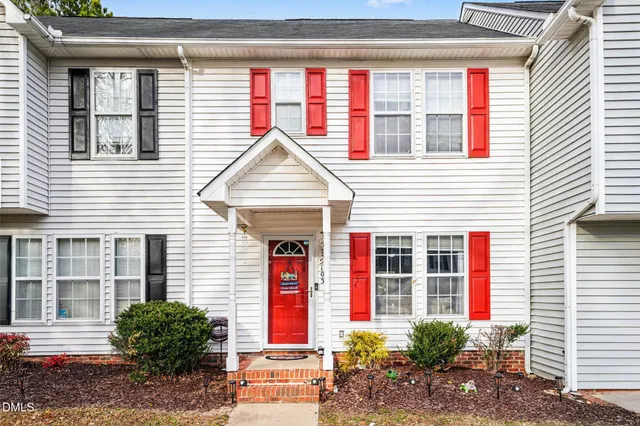 a front view of a house with a yard and potted plants