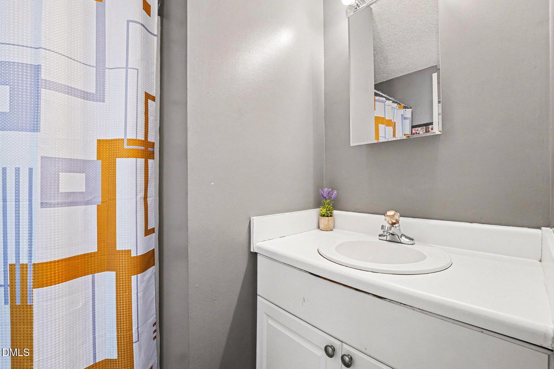 5103 Jimmy Ridge Place Raleigh, NC 27610 - Photo 21 of 29 a bathroom with a sink and a mirror