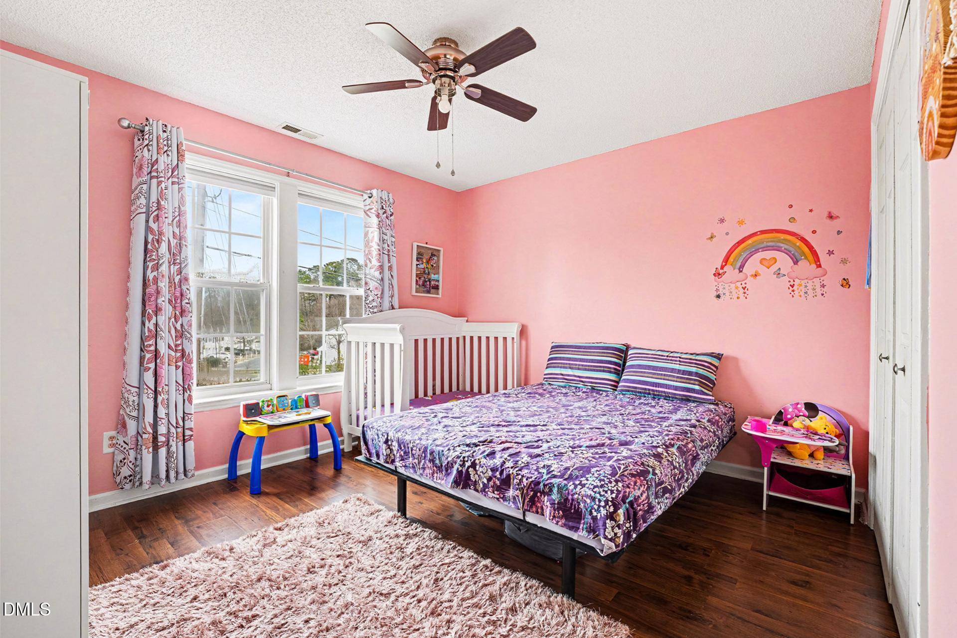 5103 Jimmy Ridge Place Raleigh, NC 27610 - Photo 22 of 29 a bedroom with a bed a chandelier and a window