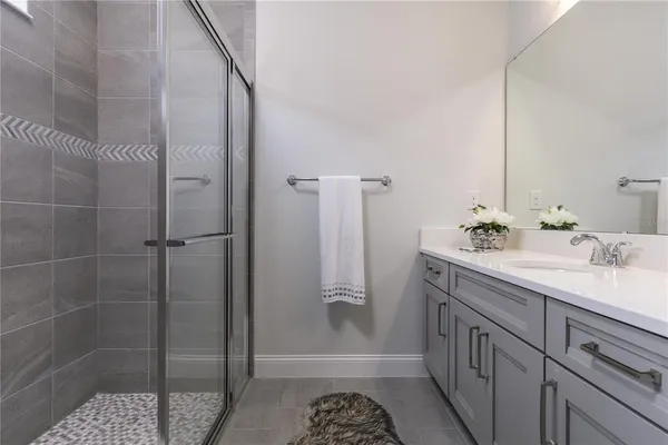 a bathroom with a shower sink and mirror