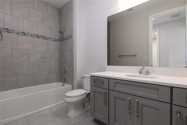 a bathroom with a granite countertop sink a toilet and shower